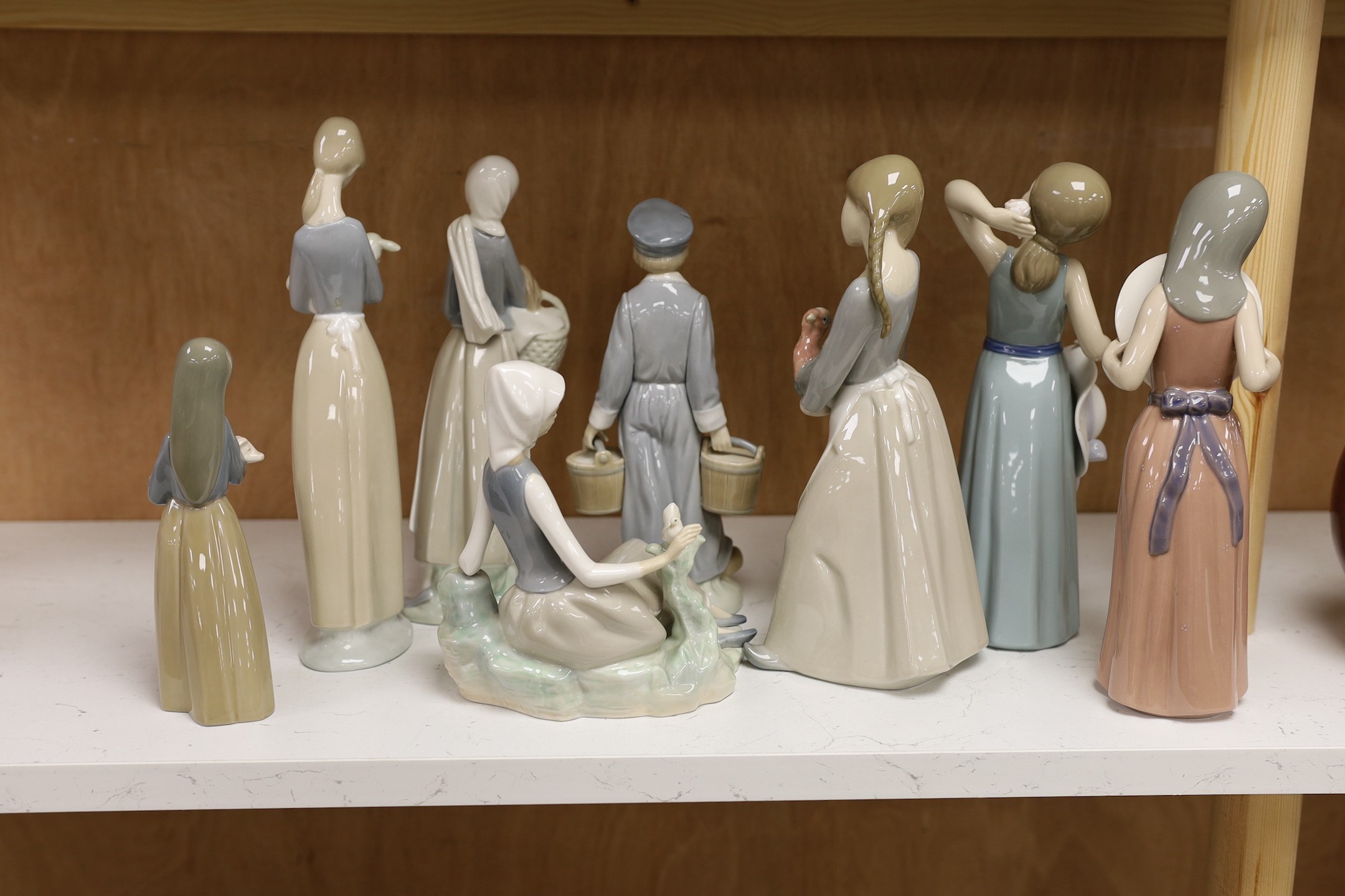 A collection of eight various Lladro figure groups to include a girl with lamb, a seated girl, etc- tallest girl holding a turkey 25 cms high.